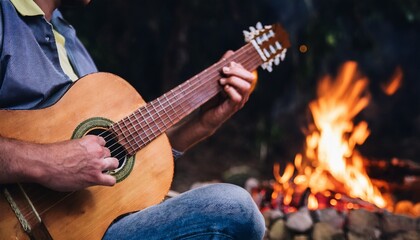 Obraz premium Man playing guitar in front of a campfire
