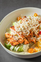 Top view of chicken caesar salad on grey stone table