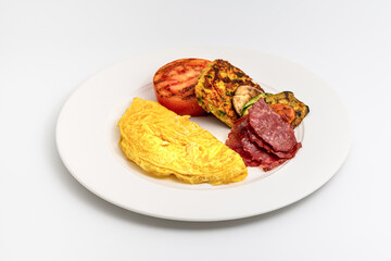 Rustic breakfast plate with fried eggs, grilled vegetables, and turkey bacon
