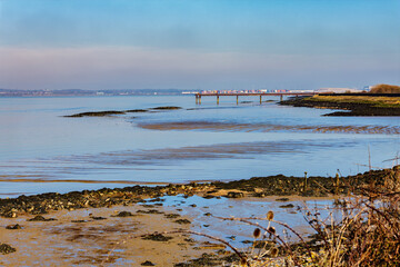 A pier over the river thames viewed from the Cliffe RSPB nature reserve near Gravesend in Kent,...