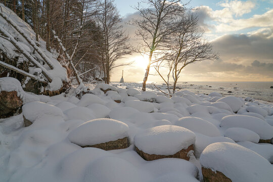 Vidzeme rocky coast in winter with a view of Ķurmjrags lighthouse. Latvia.