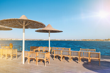 Obraz premium Wooden pier on sea stretching into distance beyond horizon on sunny summer day. Vacation and Travel Concept.