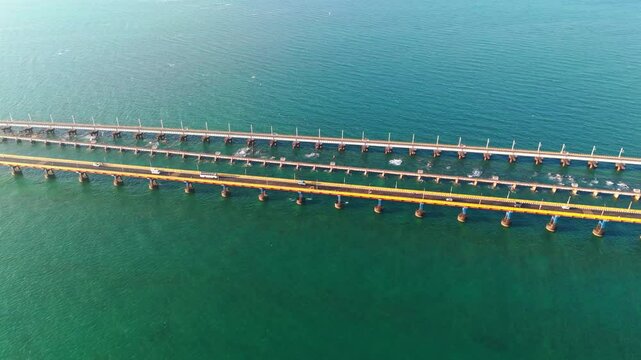 aerial footage of the Pamban Bridge extending across blue ocean