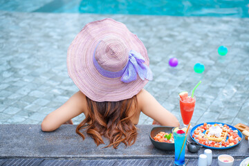 Beautiful Asain women with bikini enjoy summer vacation in the swimming pool.	