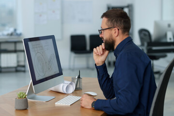Naklejka premium Technician making digital engineering drawing on computer at desk in office