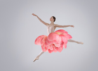 Fototapeta premium Young ballerina dancing on grey background. Peony flower instead of woman's skirt