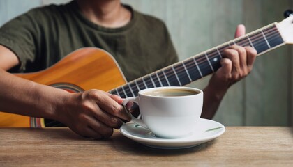 Fototapeta premium A cup of coffee and hands playing a guitar