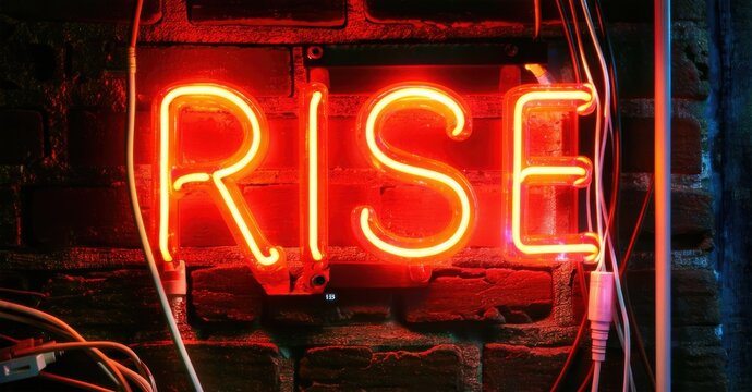 Naklejki Bold neon sign glowing rise in thick block letters bright orange and red hues on dark brick wall surrounded by electric sparks and cables