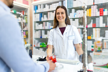 Cashier at the pharmacy store giving medicine at counter. Explaining and recommending the medicine...