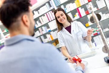 Cashier at the pharmacy store giving medicine at counter. Explaining and recommending the medicine...