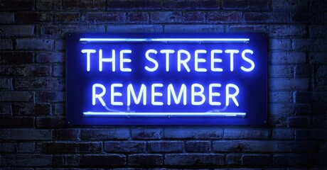 Fototapeta premium Neon streets remember sign glowing softly on old brick wall deep navy and bright silver symbolizing history of underground movements