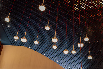 eco lamps in the exhibition hall. round lamps on the background of perforated aluminum
