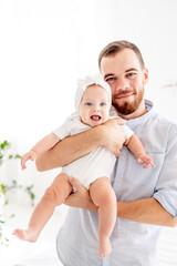 a happy dad with a little newborn daughter, the concept of fatherhood, a dad on maternity leave with a baby in his arms, a cute photo of a dad with a daughter