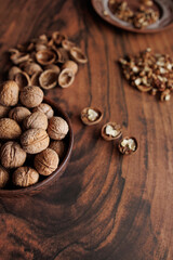 bowl of walnuts and nutcracker on wooden table