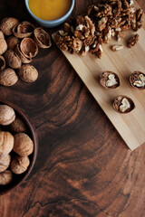 Obraz premium honey, bowl with walnuts and hazelnuts on wooden background