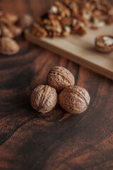 a lot of whole walnuts in a bowl with a wooden background, close - up, selective focus, horizontal