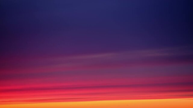 Colorful sky with gradient hues of red, orange, and purple at sunset, time lapse. Natural atmospheric background. Abstract nature scene with copy space.