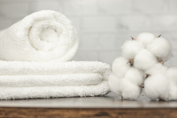Terry towels beautifully folded on a shelf. Cotton flowers