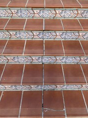 Top-down view of decorative tiled staircase in Marbella, Spain. Terracotta and patterned ceramics create a rustic Mediterranean feel