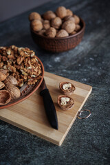 walnuts and hazelnuts on a wooden board on a gray background