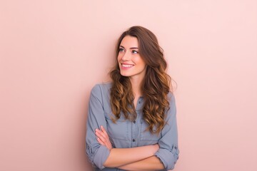 Obraz premium Attractive Young Woman with Long Brown Hair Smiling Confidently Against a Pink Background