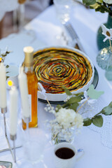 A pie sits on a decorated table surrounded by candles and flowers