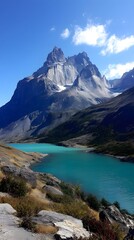 Fototapeta premium Majestic Peaks Reflecting: The grandeur of towering mountain peaks is mirrored in the serene turquoise waters of a pristine lake under a cloudless azure sky, evoking a sense of wonder and peace.