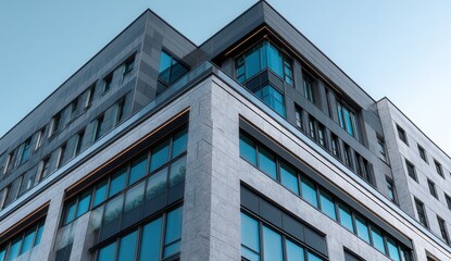 Modern office building with glass windows against a clear sky.