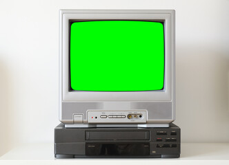 Old silver vintage green screen TV and VCR.