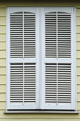 White Wooden Window Shutters on Yellow House Exterior