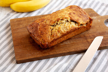 Homemade Banana Bread on a wooden board, side view.