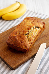 Homemade Banana Bread on a wooden board, side view.