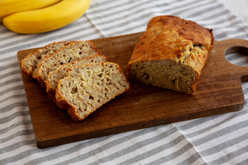 Homemade Banana Bread on a wooden board, side view.
