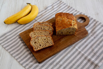 Homemade Banana Bread on a wooden board, side view.