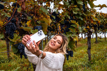 Smiling woman taking a selfie in an autumn vineyard, in Stuttgart, Germany
