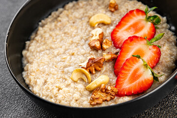 Oatmeal porridge strawberries nuts healthy breakfast appetizer dish fresh delicious gourmet food background on the table rustic food top view copy space keto and paleo diet vegetarian and vegan food