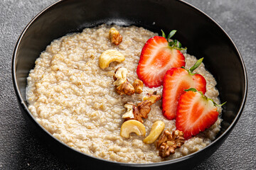 Oatmeal porridge strawberries nuts healthy breakfast appetizer dish fresh delicious gourmet food background on the table rustic food top view copy space keto and paleo diet vegetarian and vegan food