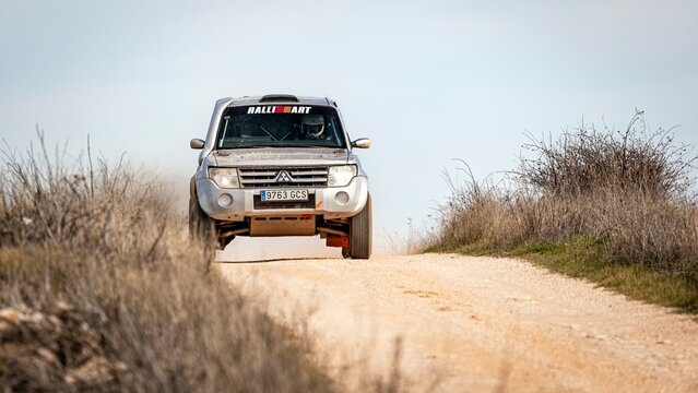 Madrid, Spain; 02-15-2025: Grey Mitsubishi Montero DID powers through an offroad rally stage, kicking up dust as it tackles rugged terrain with precision and endurance