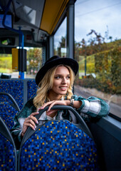Smiling woman traveling by bus on an autumn day in Stuttgart, Germany