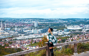 Woman escaping from city life on a hilltop with a view over Stuttgart, Germany