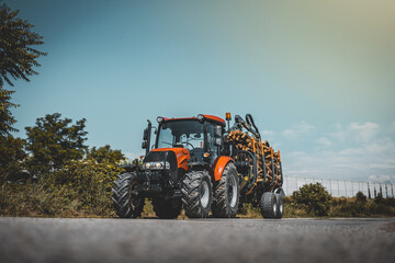 Forwarder tractor for wood transport. Tractor with trailer loaded with logs. Forestry tractor or forestry tractor for harvesting wood on the road.