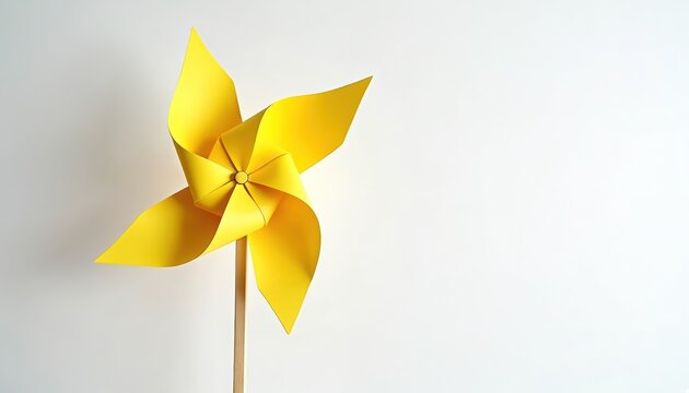 Yellow paper pinwheel isolated white background. Origami windmill toy, environmental friendly sustainable energy, decreased carbon emissions concept. Simple kids starter craft for weekend leisure