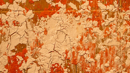 Photograph of an old cracked paint surface in different shades of light brown and orange as a wallpaper.