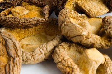 An elegant display of dried shiitake mushrooms on white, capturing their rustic texture and rich, organic color.