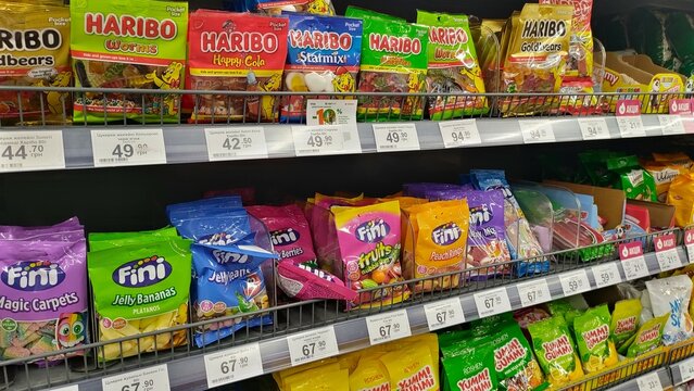 Assorted candy bags on supermarket shelf displaying colorful variety of sweet treats. concept of snack choices, shopping, sweet indulgence