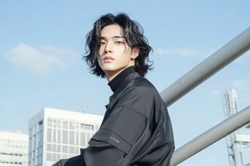 Young man posing stylishly in urban setting.