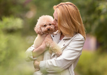 young woman hanging  her toy puddle dog in the green park