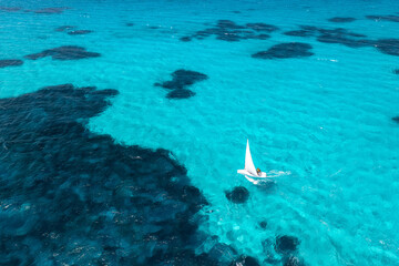 Aerial view of sailboat on blue sea on summer sunny day. Travel in Sardinia, Italy. Tropical...