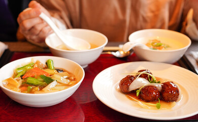 酢豚と五目あんかけ焼きそばのランチセットを食べる女性