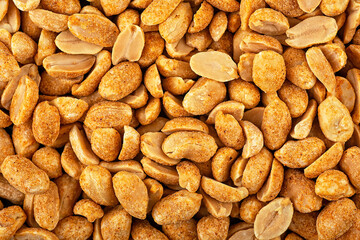 Roasted and spiced peanuts as background, top view. Peeled chili spicy peanuts.